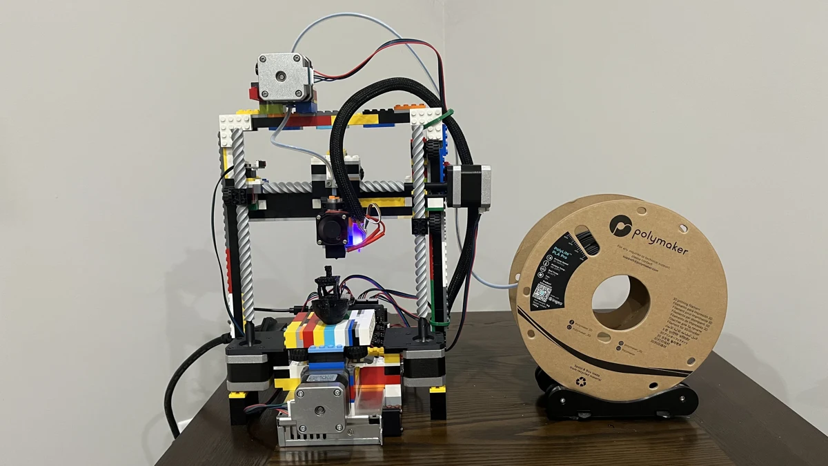 Studprint s rámem z LEGO kostek a cívkou filamentu vedle tiskárny